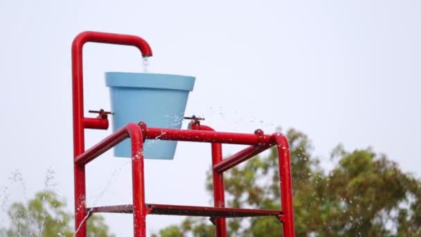 Seau coloré éclaboussure dans un parc aquatique — Video