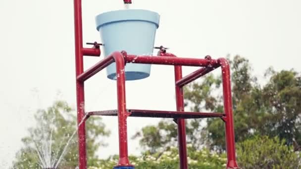 Colorful bucket splash in aqua park — Stock Video