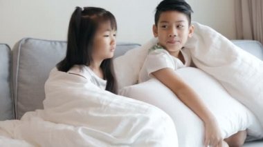 Kanepede televizyon izlerken küçük Asya çocuklar