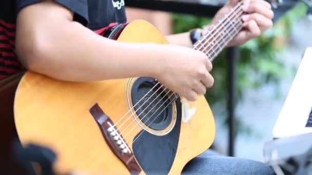 Nahaufnahme eines nicht identifizierten Mannes, der einen Gitarrenklassiker spielt — Stockvideo