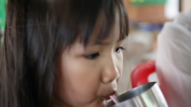 Joven niño asiático bebiendo un vaso de agua  . — Vídeo de stock