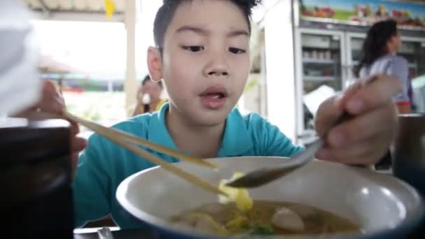 Счастливый азиатский ребенок ест лапшу — стоковое видео