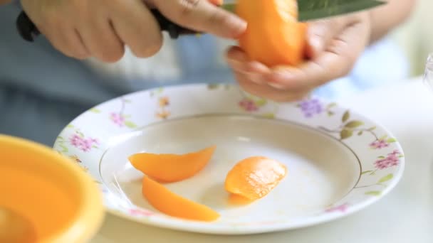 Gros plan femme main coupant une prune mariale — Video