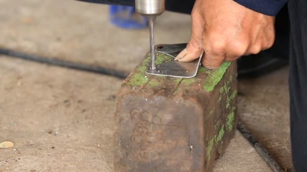 Human hand drill a hole into a piece of metal . — Stock Video