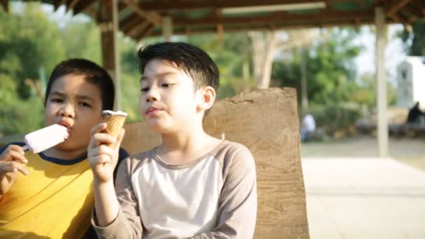 Aziatische kindje genieten van het eten van ijs samen — Stockvideo