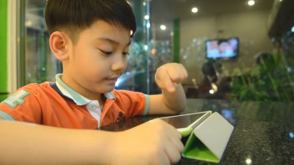 Menino com um tablet PC na sala de recreação — Vídeo de Stock