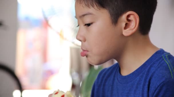 Pequeño niño asiático comiendo donut sweet food — Vídeo de stock