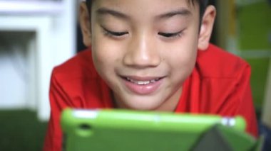 Küçük Asyalı çocuk dijital tablet kullanıyor. .