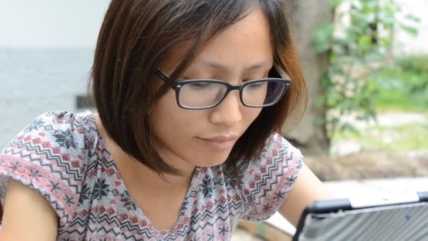 Ασιατικές γυναίκα χρησιμοποιώντας tablet PC στο πάρκο . — Αρχείο Βίντεο