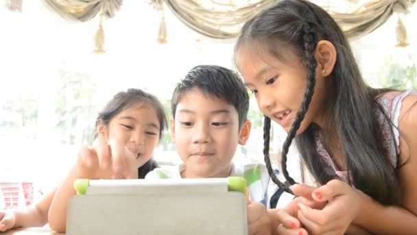 Grupo de niños asiáticos jugando con un touchpad durante el almuerzo — Vídeo de stock