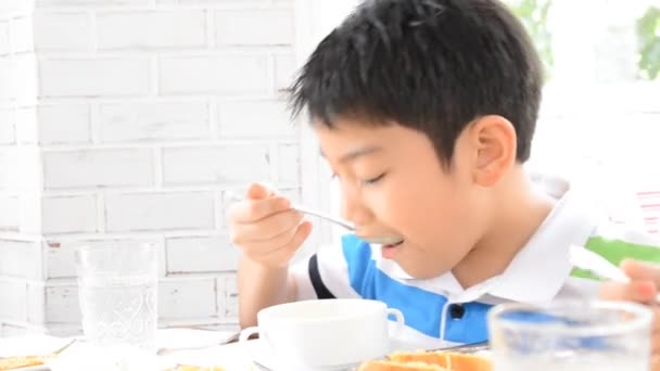 Kleines asiatisches Kind isst zu Hause selbst Suppe — Stockvideo