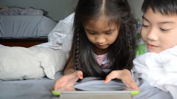 Menina asiática e menino jogar no tablet na cama — Vídeo de Stock