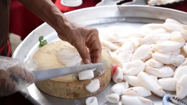 Kniven skär bläckfisk på en trä kök ombord, förbereder sig för matlagning. — Stockvideo