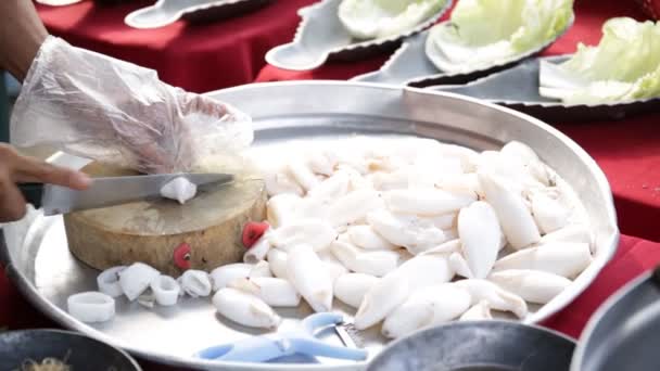 Messer schneidet Kraken auf einem hölzernen Küchenbrett, bereitet sich auf das Kochen vor. — Stockvideo