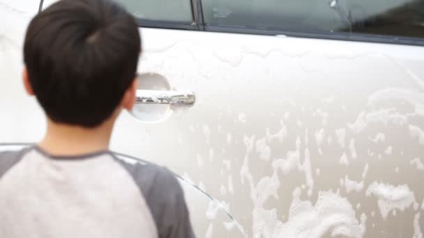 Aziatische schattige jongen wassen auto. Kind helpen schoon grote gezinsauto. — Stockvideo