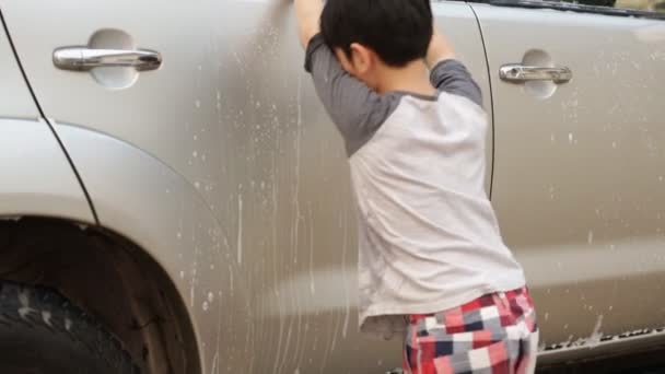 Aziatische schattige jongen wassen auto. Kind helpen schoon grote gezinsauto. — Stockvideo