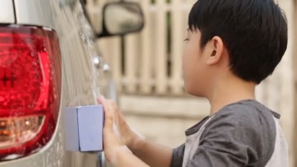 Asiatique mignon garçon lavage de voiture. Enfant aidant la famille à nettoyer grande voiture . — Video