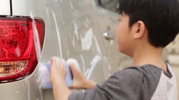 Asiatique mignon garçon lavage de voiture. Enfant aidant la famille à nettoyer grande voiture . — Video