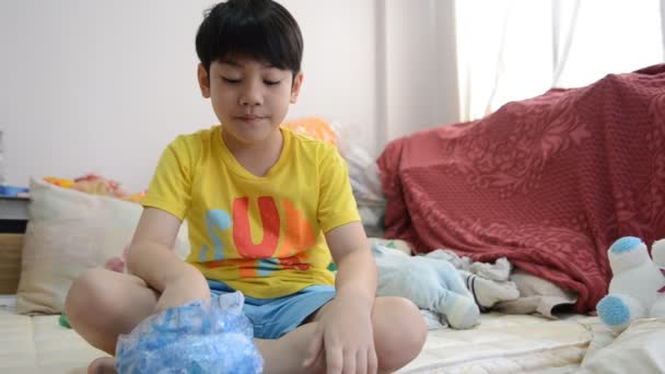 Pequeño niño asiático comiendo comida dulce — Vídeos de Stock