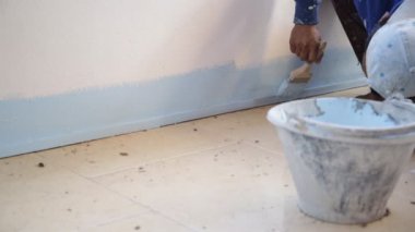 Mavi boya ile el işçisi boyama closeup .