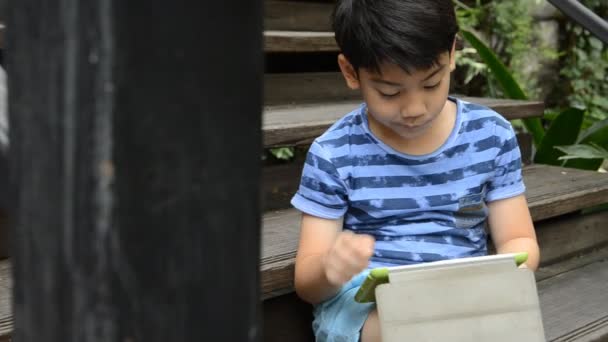 Kleines asiatisches Kind mit digitalem Tablet . — Stockvideo