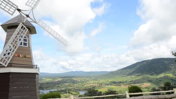 PETCHABOON, THAILAND-AUG 11,2014: Moinho de vento Wellcome com vista de fundo para a paisagem montanhosa — Vídeo de Stock