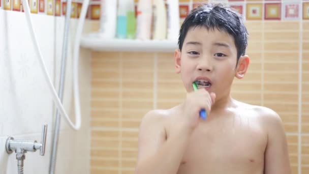 Unga asiatiska pojken borsta tänderna i badrum — Stockvideo
