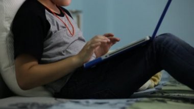 Asya sevimli çocuk izliyor ve dizüstü bilgisayar üzerinde konuşuyor.