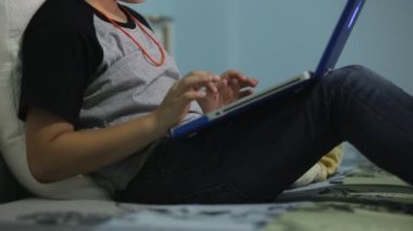 Asya sevimli çocuk izliyor ve dizüstü bilgisayar üzerinde konuşuyor.