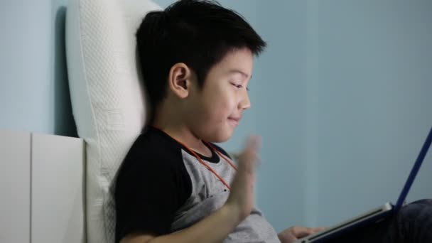Asya sevimli çocuk izliyor ve dizüstü bilgisayar üzerinde konuşuyor. — Stok video