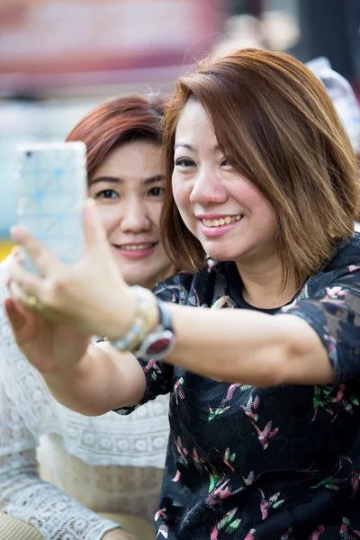Happy asiatisk kvinna med vän med en selfie — Stockfoto