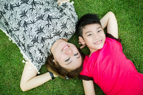 Felice bambino asiatico con madre giocare all'aperto nel parco — Foto Stock