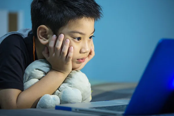 Pequeño niño asiático usando el ordenador portátil en casa —  Fotos de Stock