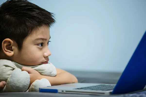 Pequeño niño asiático usando el ordenador portátil en casa — Foto de Stock