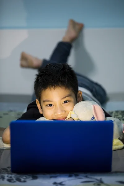 Pequeño niño asiático usando el ordenador portátil en casa —  Fotos de Stock