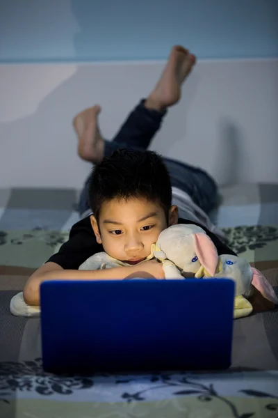 Pequeño niño asiático usando el ordenador portátil en casa —  Fotos de Stock