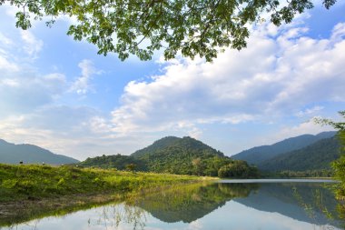 Orman gölü Mavi bulutlu gökyüzünün altında