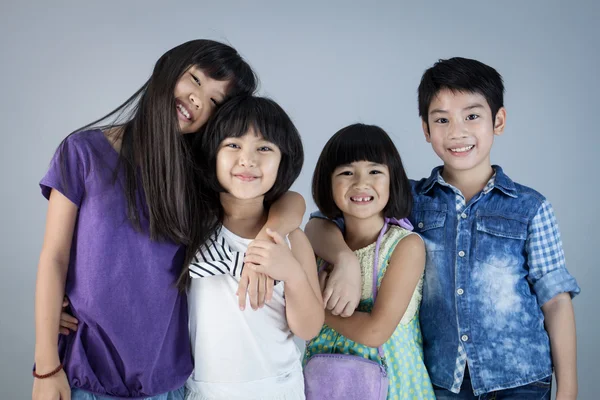 Група щасливі азіатських дитини на сірий фон — стокове фото