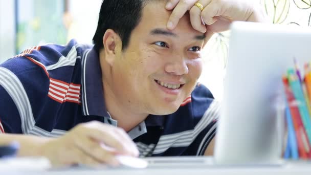 Feliz hombre asiático usando su portátil y sonrisa — Vídeos de Stock