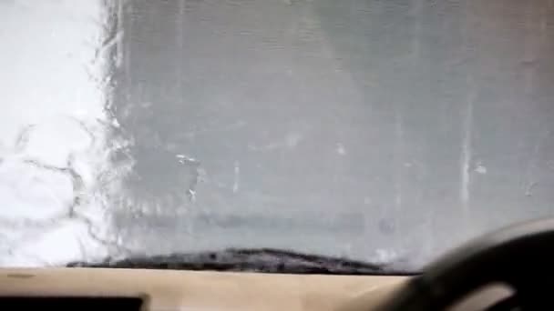 Bilden av regn droppar faller på en bil fönstret med bilen torkar gör — Stockvideo