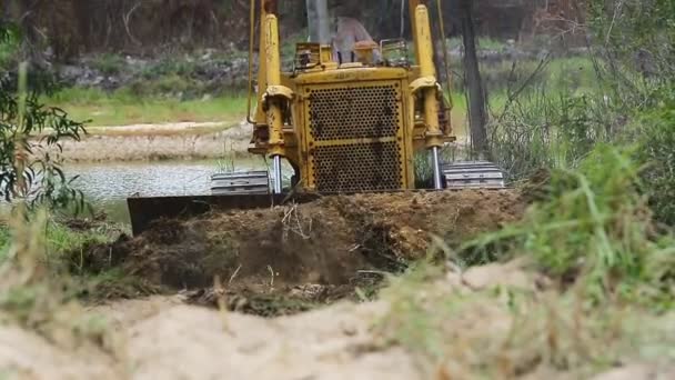 Control de trabajadores no identificado Bulldozer a excavadora niveladora quitando el suelo — Vídeo de stock