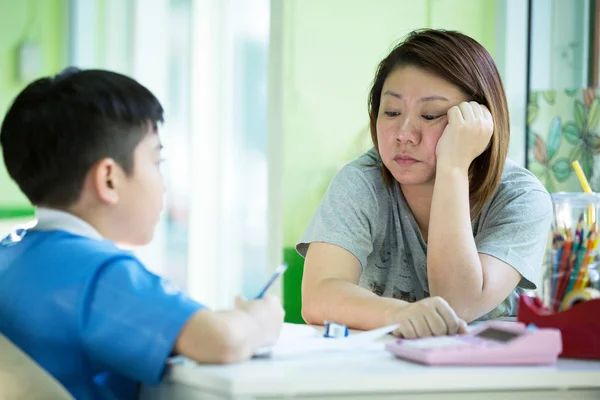 Serious Asian Mother Helping Son With Homework — Stock Photo, Image