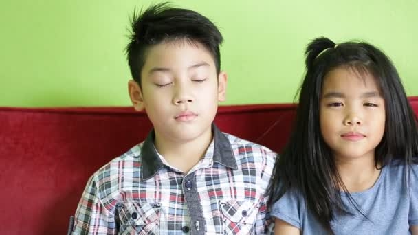 Happy asian boy and girl looking at camera and smiling. Sequence in relax room — Stock Video