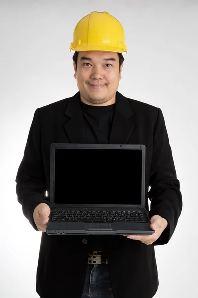 Portrait of asian smiling holding laptop with safety helmet — Stockfoto