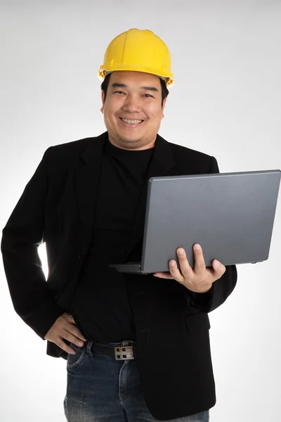 Portrait of asian smiling holding laptop with safety helmet — стокове фото