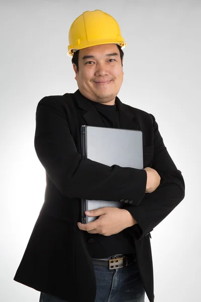 Retrato de asiática sonriente sosteniendo portátil con casco de seguridad — Foto de Stock