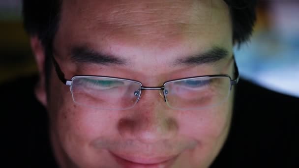 Close-up van de Aziatische man op zijn laptop kijk iets op het scherm — Stockvideo