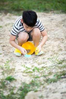 Asyalı çocuk Bahçe oyuncakları ile oynarken