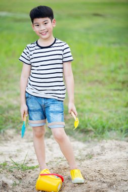 Asyalı çocuk Bahçe oyuncakları ile oynarken
