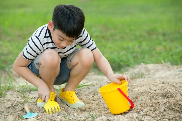 アジアの少年の庭でおもちゃで遊んで — ストック写真